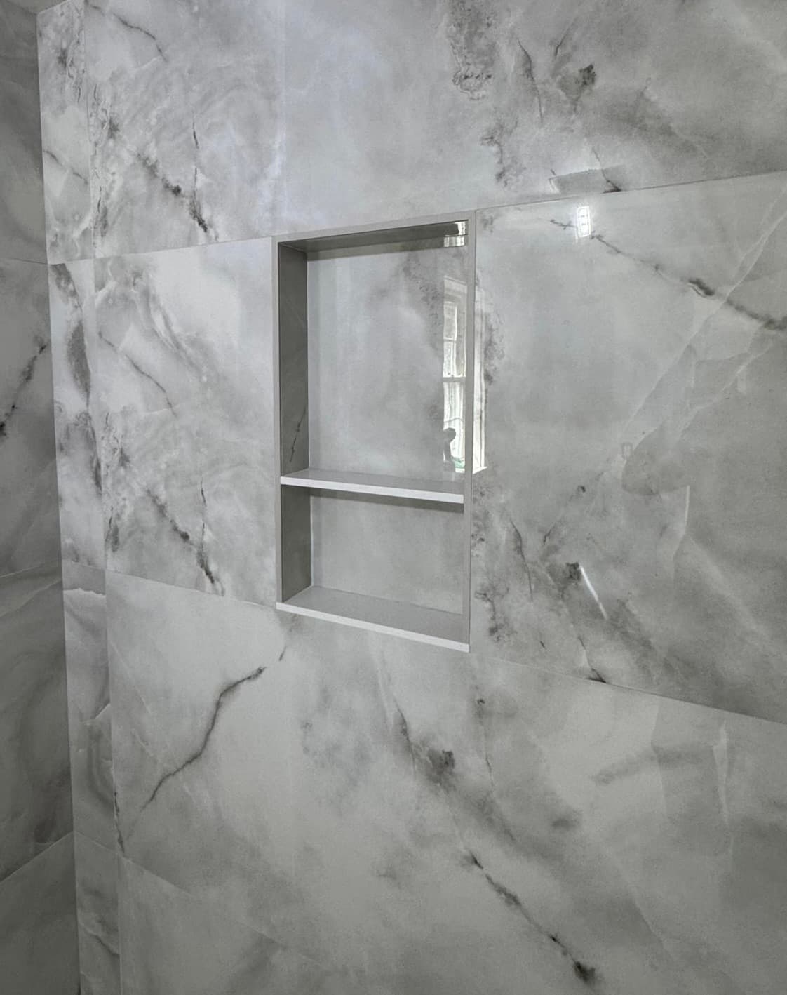 Cleanly aligned marble shower niche detail