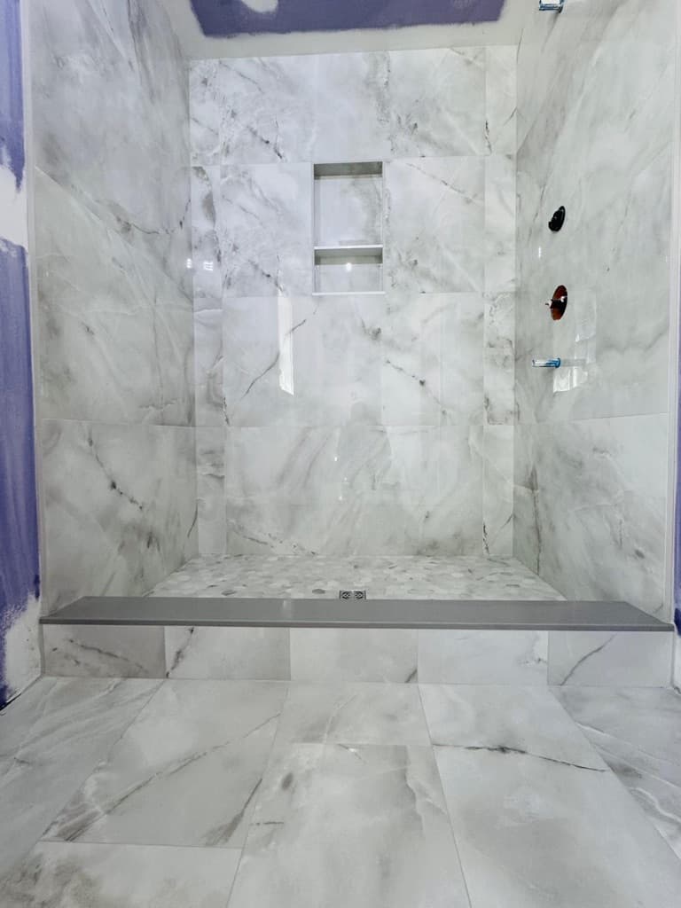 Completed marble shower showing controlled installation