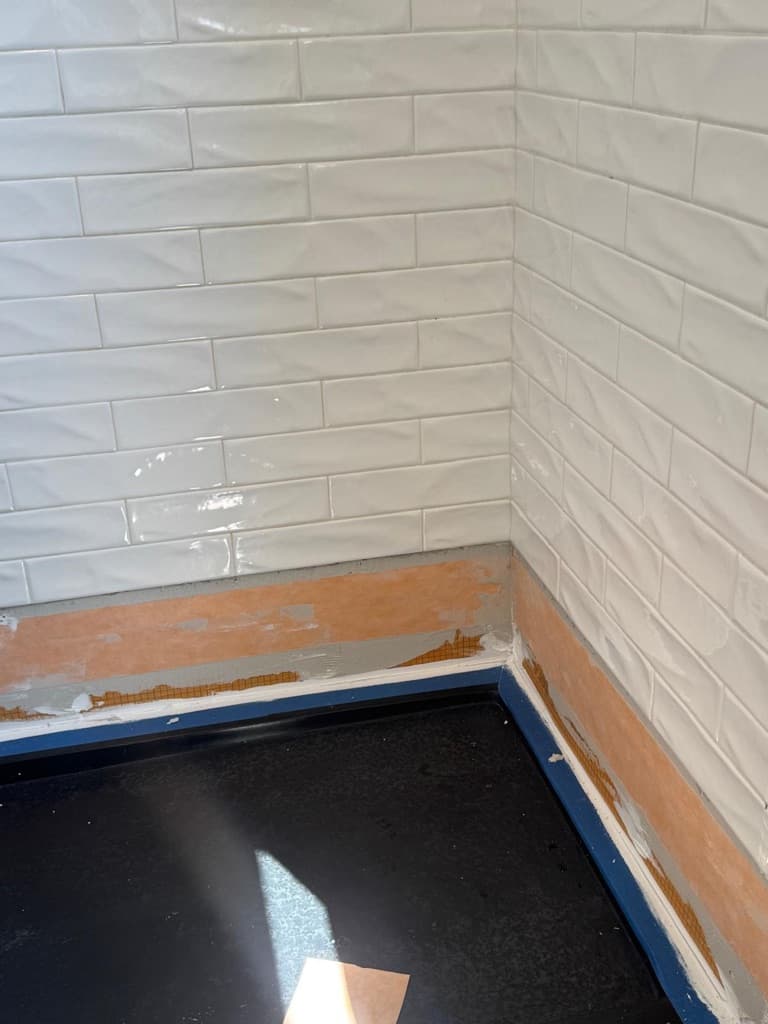 Waterproofing layer integrated at the base of the shower before final finish